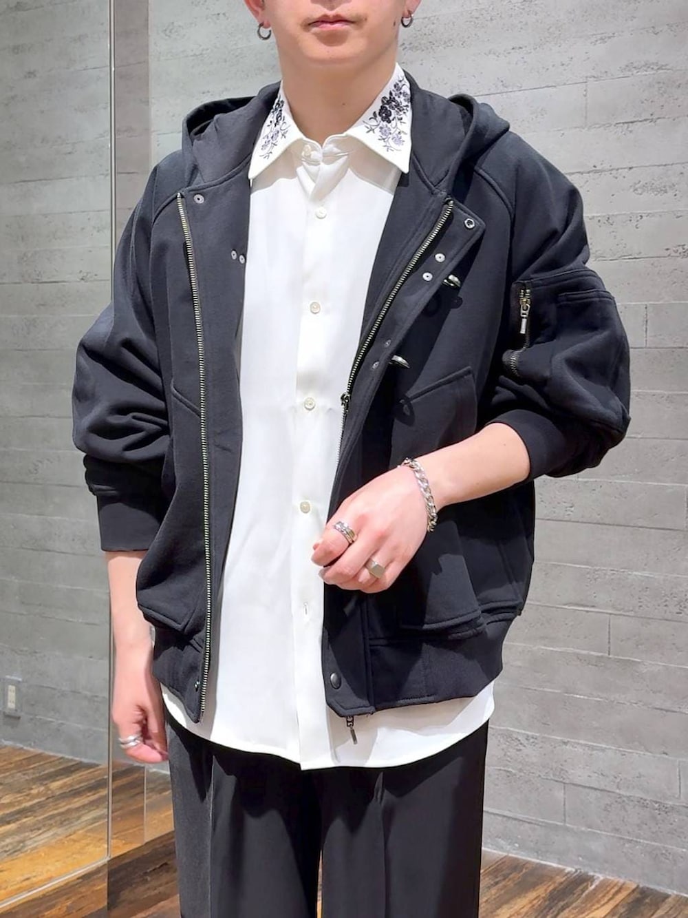 ブラック系のスラックス、ブラック系のスニーカー、ホワイト系のシャツ/ブラウスを着用したメンズの春コーディネートの5枚目の写真