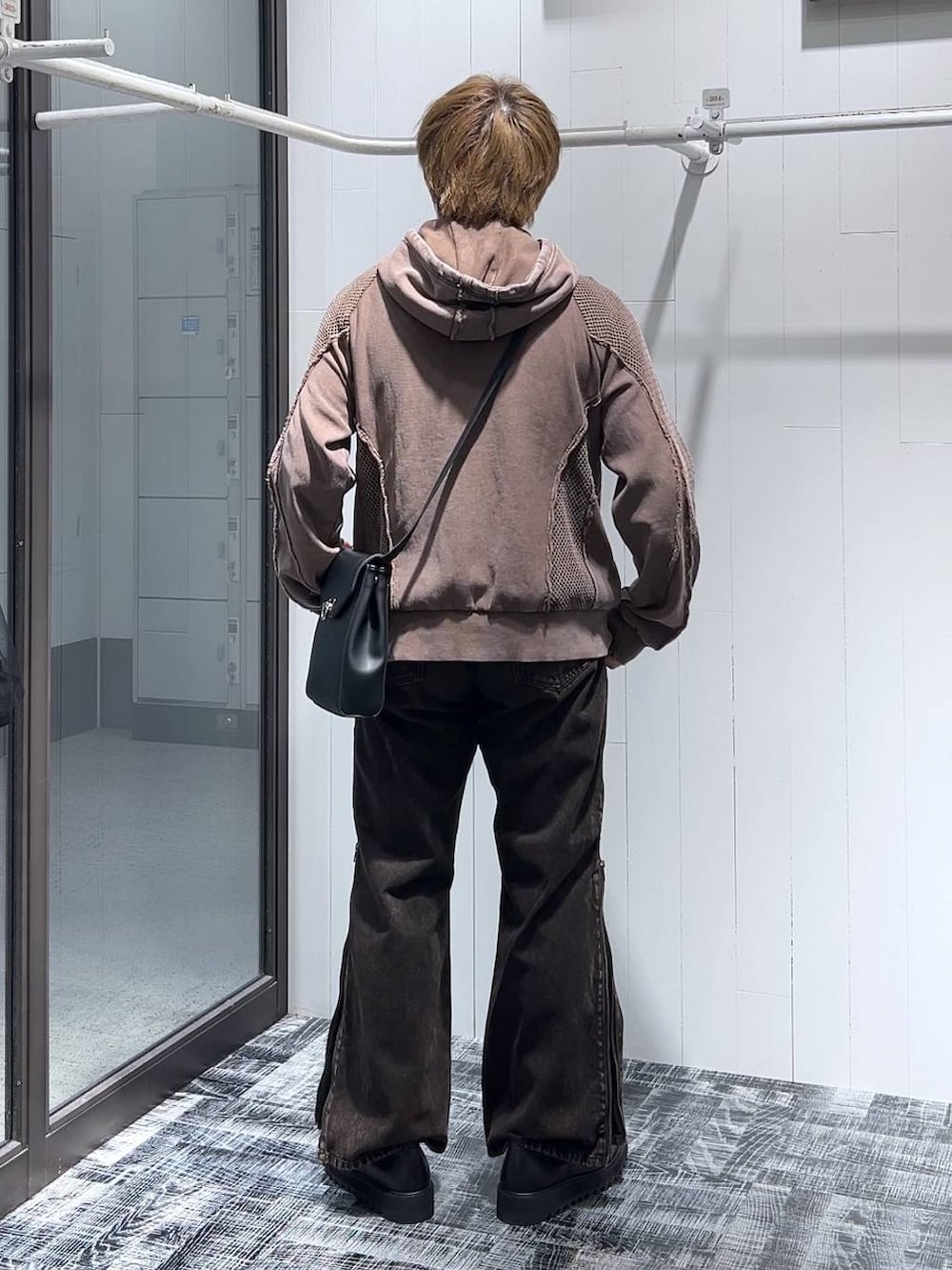 オレンジ系のデニムパンツ、ブラウン系のパーカー、ブラック系のドレスシューズを着用したメンズの春コーディネートの3枚目の写真