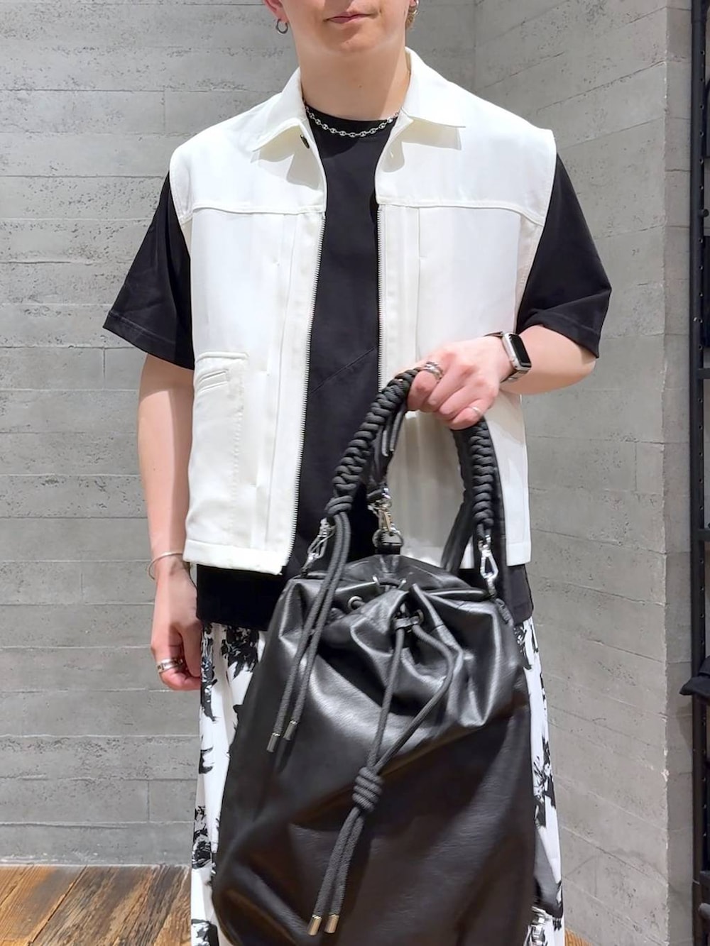 ブラック系のTシャツ/カットソー、ブラック系のサンダル、ホワイト系のスラックスを着用したメンズの夏コーディネートの5枚目の写真