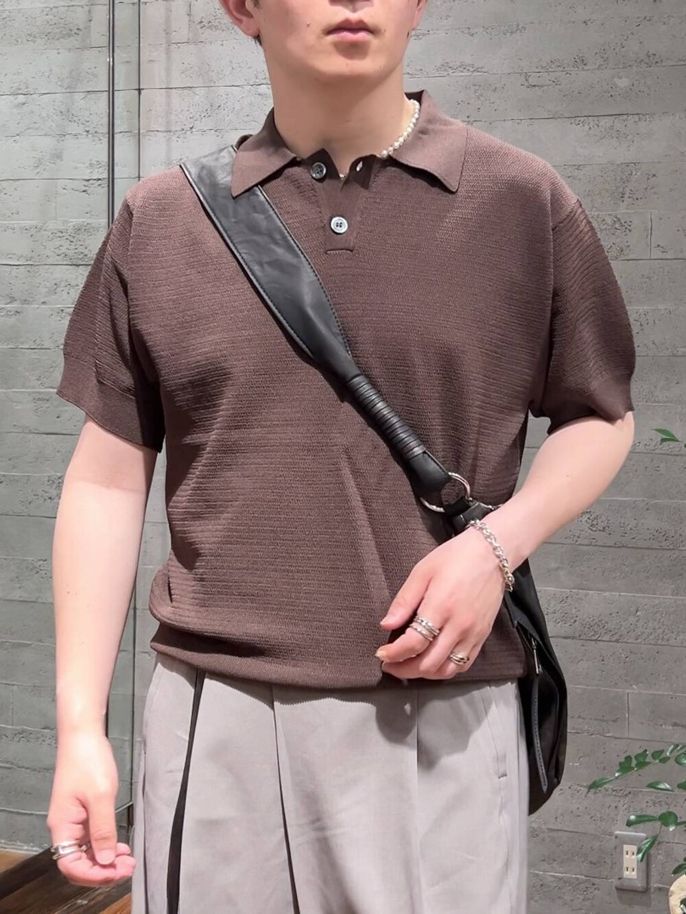 ブラック系のローファー、グレー系のショルダーバッグ、グレー系のスラックスを着用したメンズの夏コーディネートの5枚目の写真