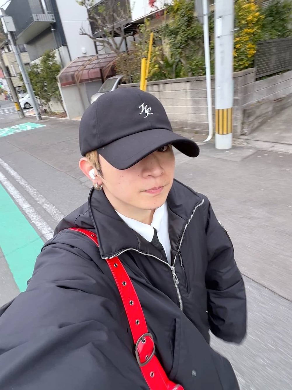 ホワイト系のシャツ/ブラウス、ブルー系のデニムパンツ、レッド系のショルダーバッグを着用したメンズの冬コーディネートの2枚目の写真