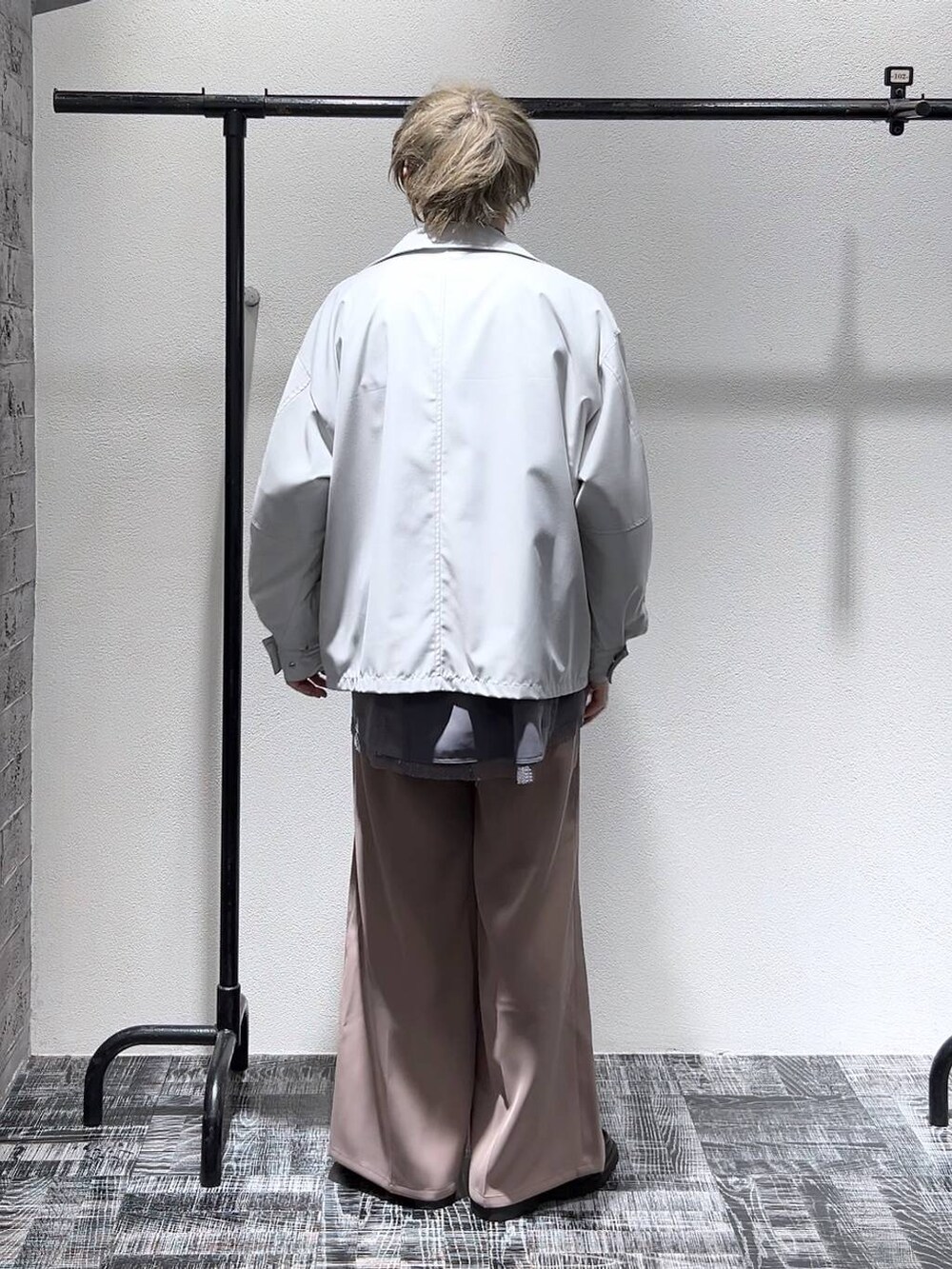 ピンク系のスラックス、グレー系のブルゾン、ブラック系のショルダーバッグを着用したメンズの冬コーディネートの4枚目の写真
