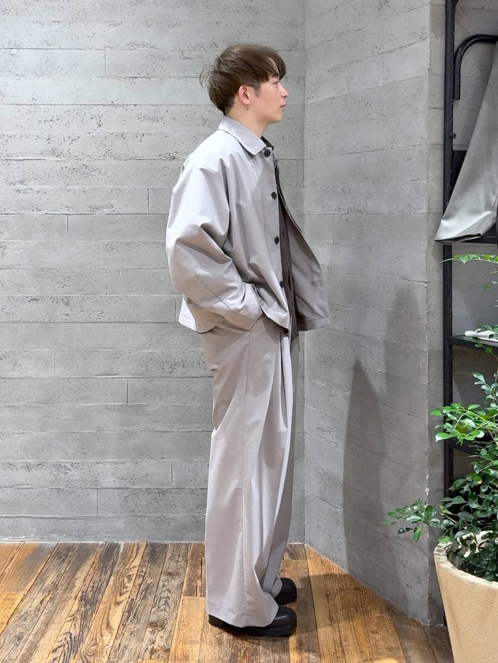 ブラック系のブーツ、グレー系のスラックス、グレー系のブルゾンを着用したメンズの冬コーディネートの2枚目の写真