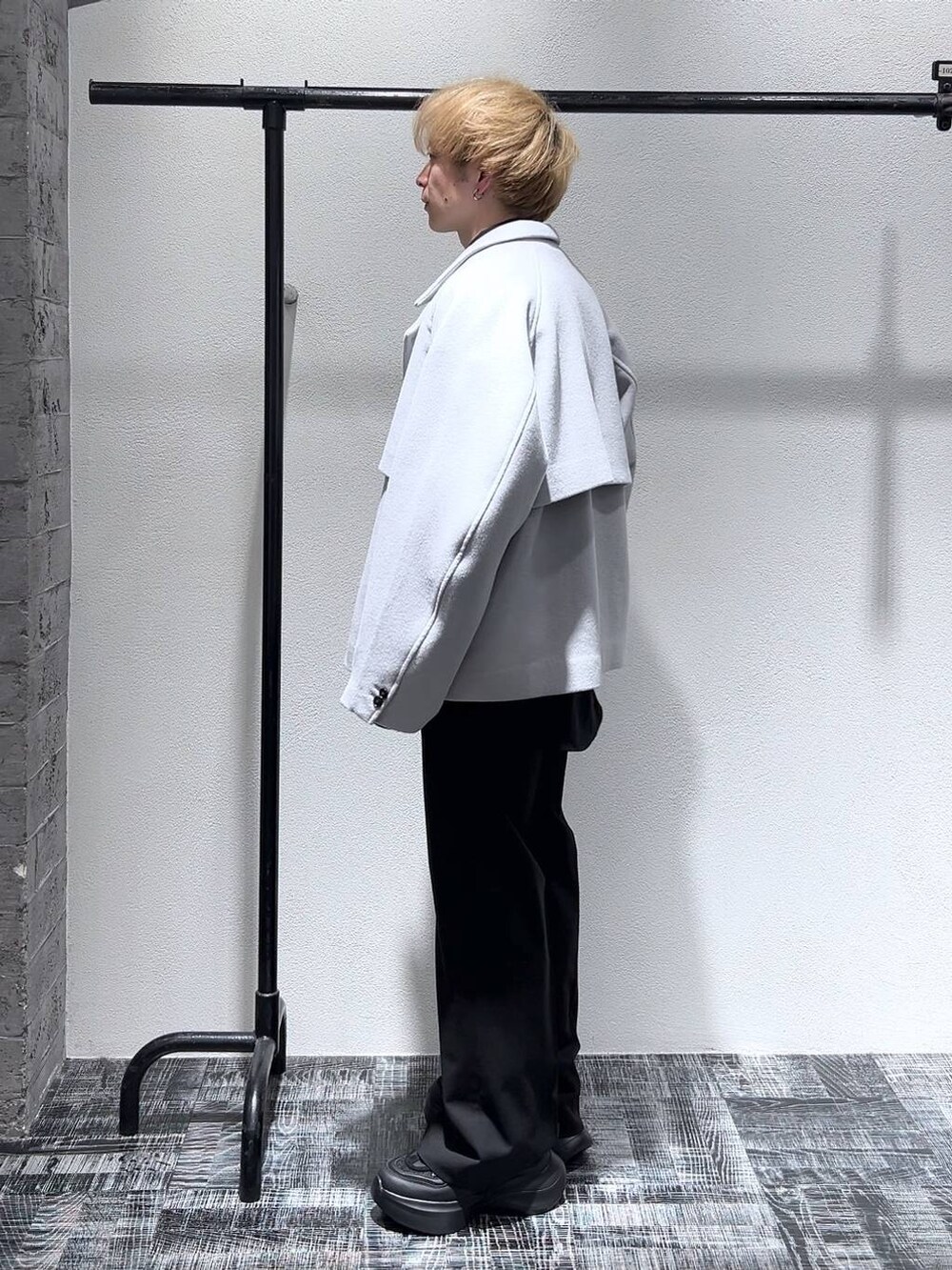 グレー系のブルゾン、ブラック系のスニーカー、ブラック系のスラックスを着用したメンズの冬コーディネートの4枚目の写真