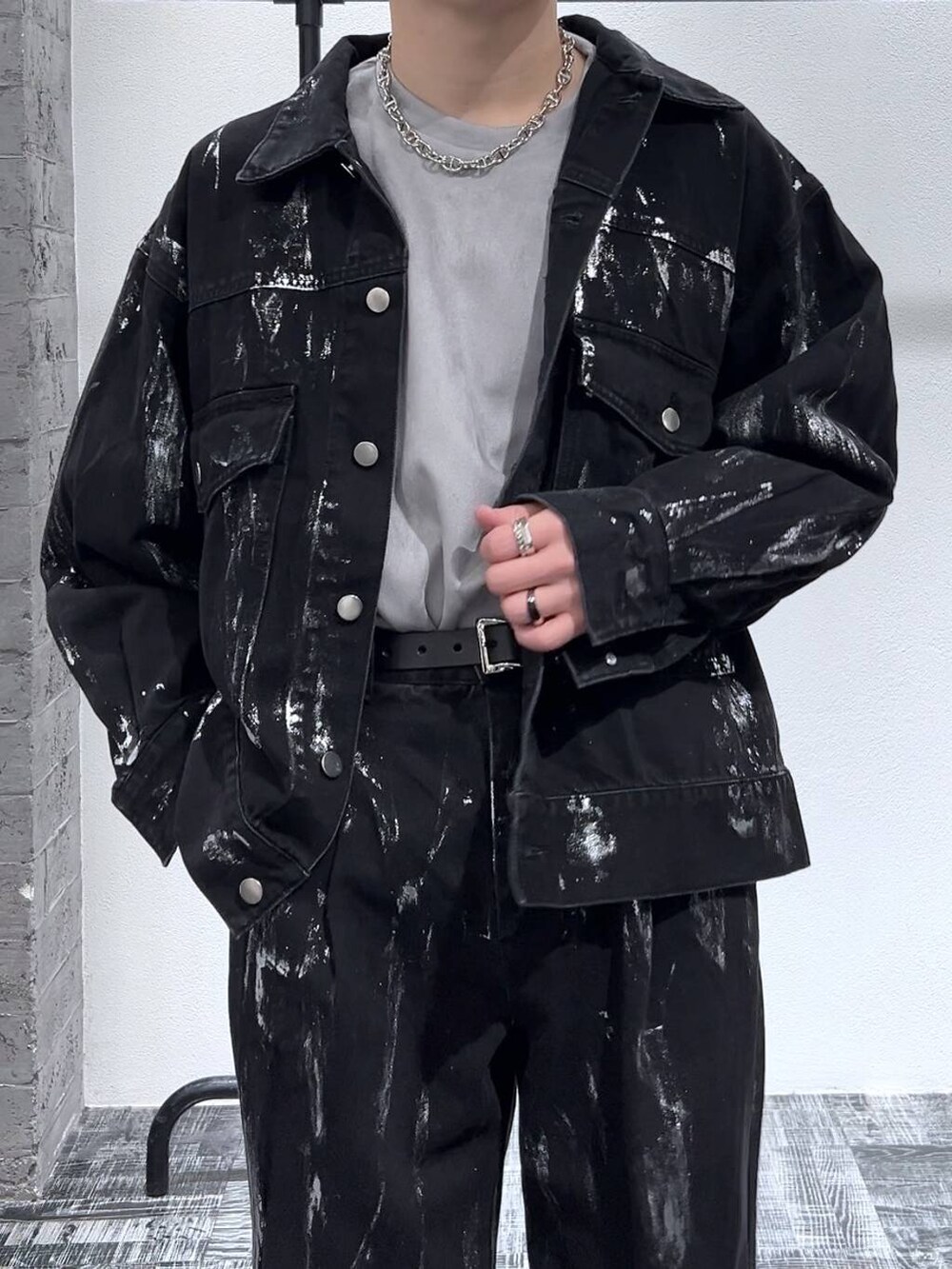 グレー系のスウェット、ブラック系のブーツ、ブラック系のデニムジャケットを着用したメンズの冬コーディネートの5枚目の写真