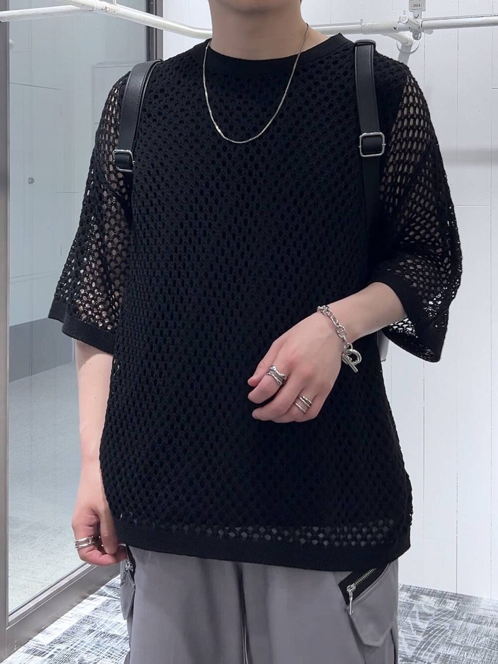 ブラック系のニット/セーター、グレー系のカーゴパンツ、ブラック系のTシャツ/カットソーを着用したメンズの春コーディネートの5枚目の写真