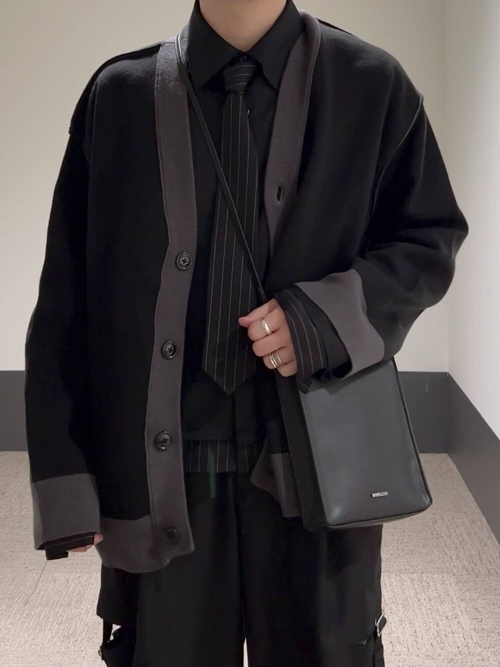 ブラック系のスラックス、ブラック系のカーディガン/ボレロ、ブラック系のシャツ/ブラウスを着用したメンズの冬コーディネートの5枚目の写真