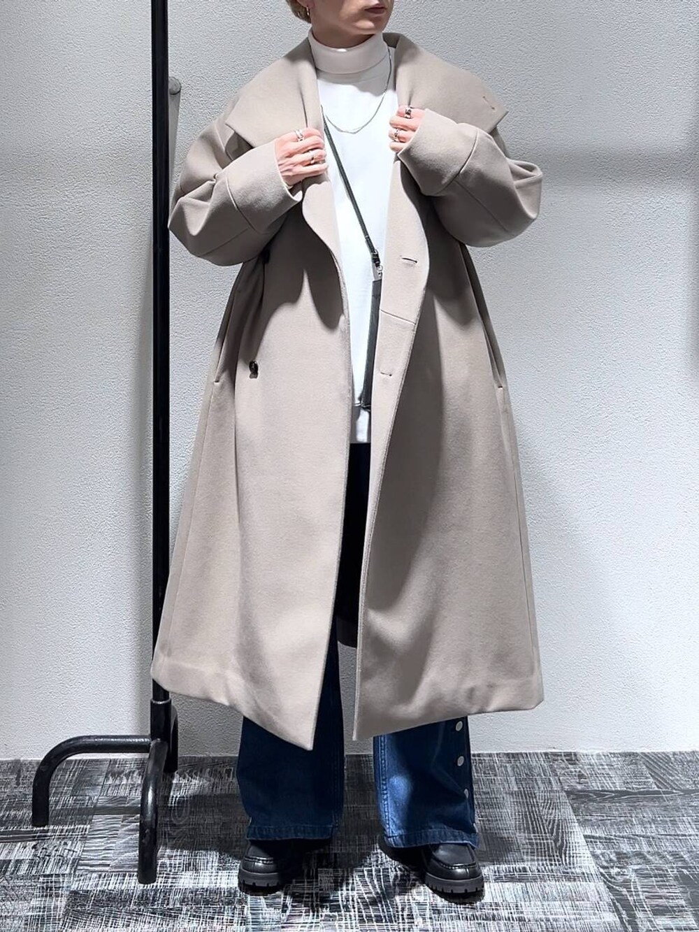 ブルー系のデニムパンツ、ブラック系のショルダーバッグ、ブラック系のドレスシューズを着用したメンズの冬コーディネートの2枚目の写真