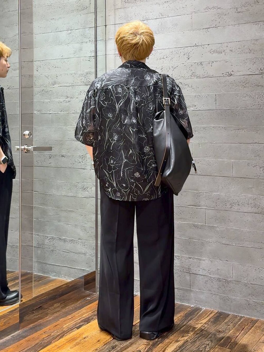 ブラック系のスラックス、ブラック系のローファー、ブラック系のTシャツ/カットソーを着用したメンズの春コーディネートの3枚目の写真