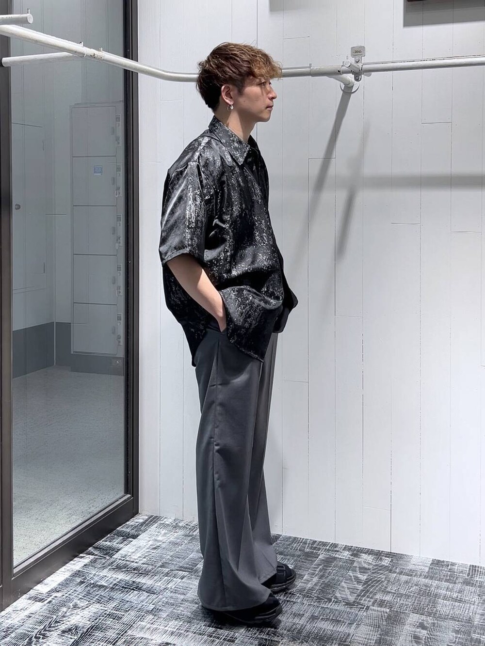 グレー系のスラックス、ブラック系のショルダーバッグ、ブラック系のサンダルを着用したメンズの夏コーディネートの4枚目の写真