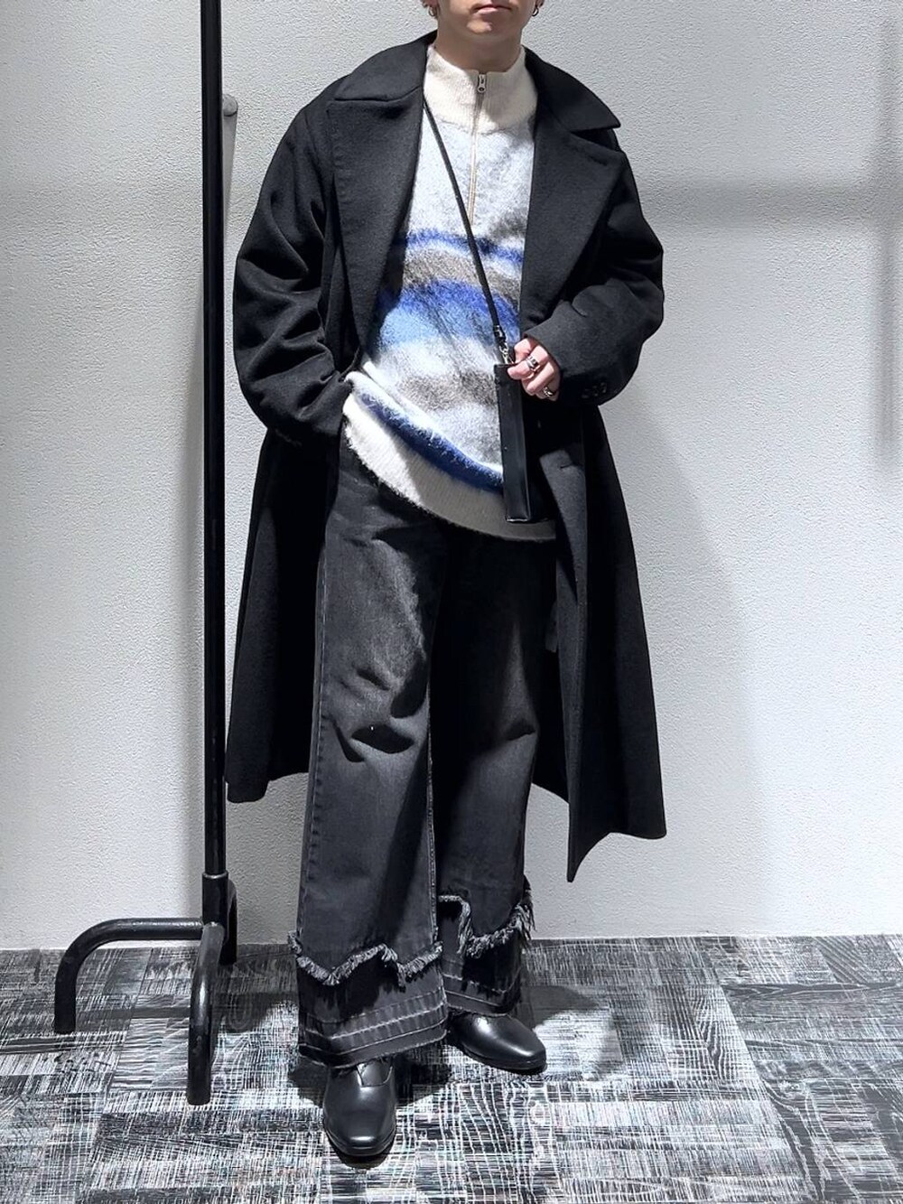 ブラック系のドレスシューズ、ブラック系のステンカラーコート、ブラック系のショルダーバッグを着用したメンズの冬コーディネートの2枚目の写真