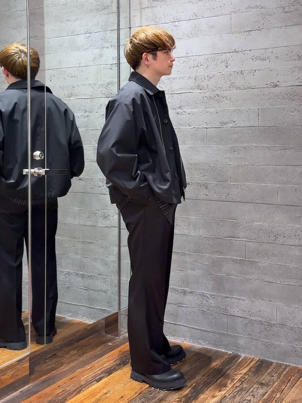 ブラック系のスラックス、ブラック系のブルゾン、ブラック系のシャツ/ブラウスを着用したメンズの春コーディネートの2枚目の写真