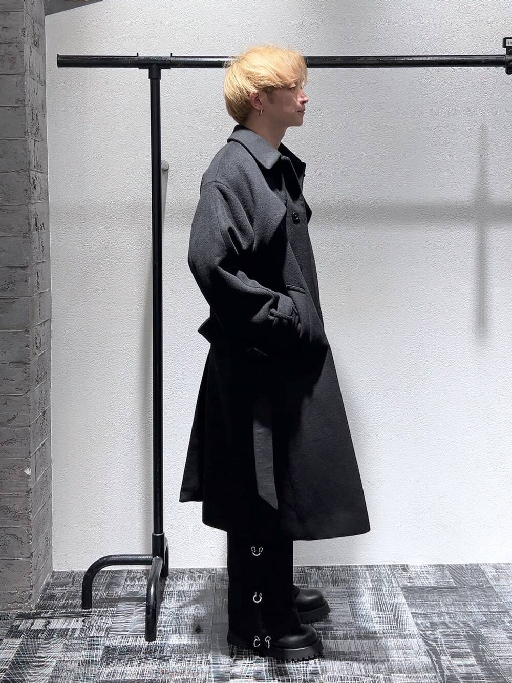 ブラック系のステンカラーコート、ブラック系のブーツ、グレー系のスウェットを着用したメンズの秋コーディネートの4枚目の写真