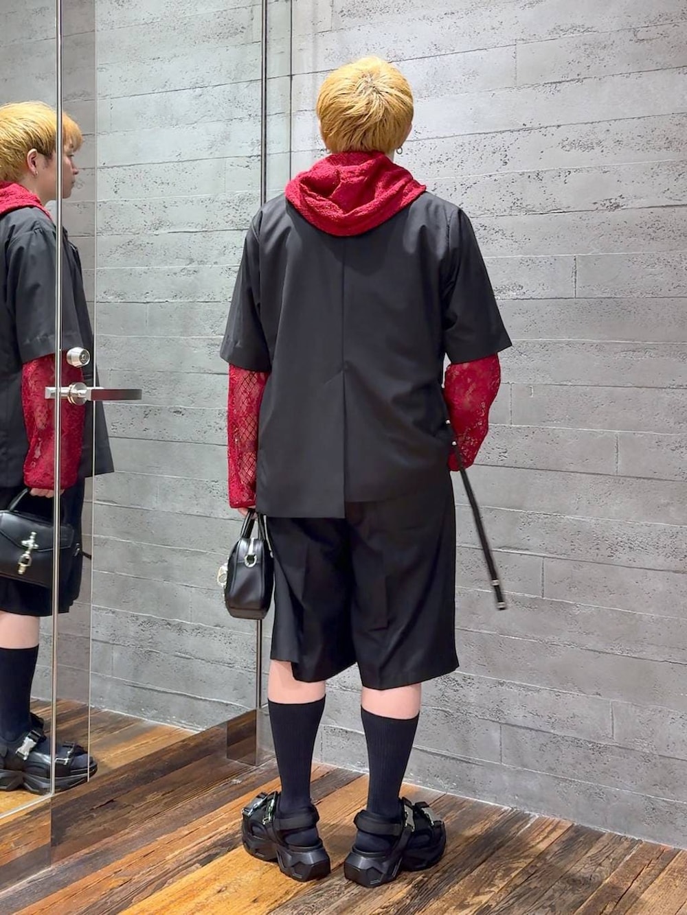ブラック系のサンダル、ホワイト系のTシャツ/カットソー、ブラック系のショルダーバッグを着用したメンズの夏コーディネートの3枚目の写真