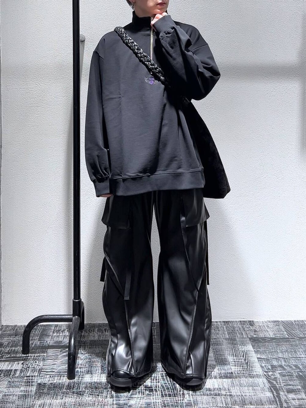 ブラック系のドレスシューズ、ブラック系のスウェット、ブラック系のショルダーバッグを着用したメンズの冬コーディネートの2枚目の写真