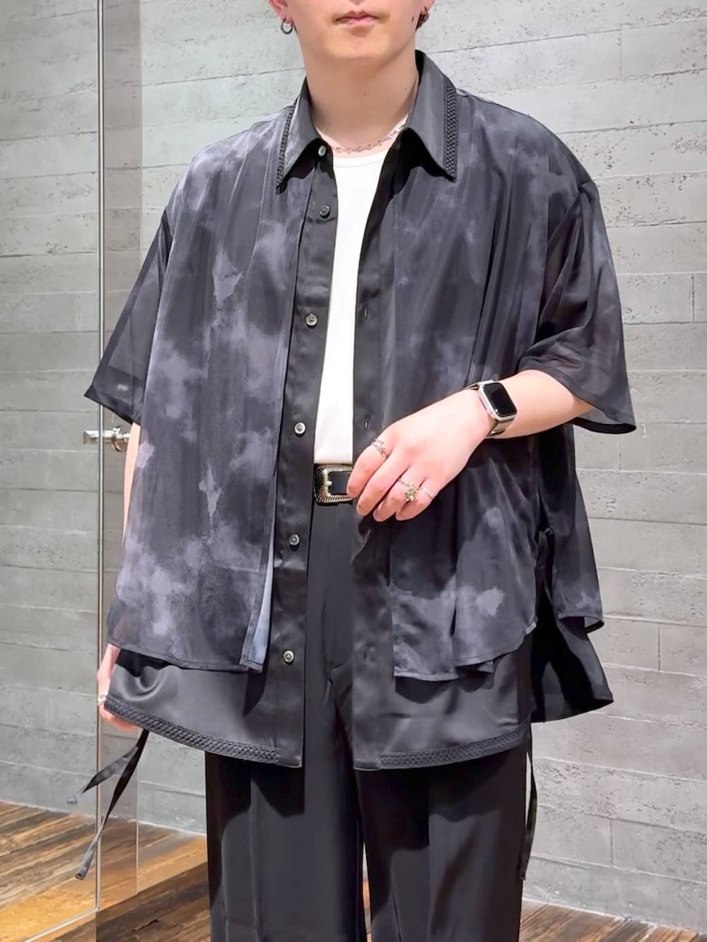 ブラック系のスラックス、ホワイト系のTシャツ/カットソー、ブラック系のサンダルを着用したメンズの夏コーディネートの5枚目の写真