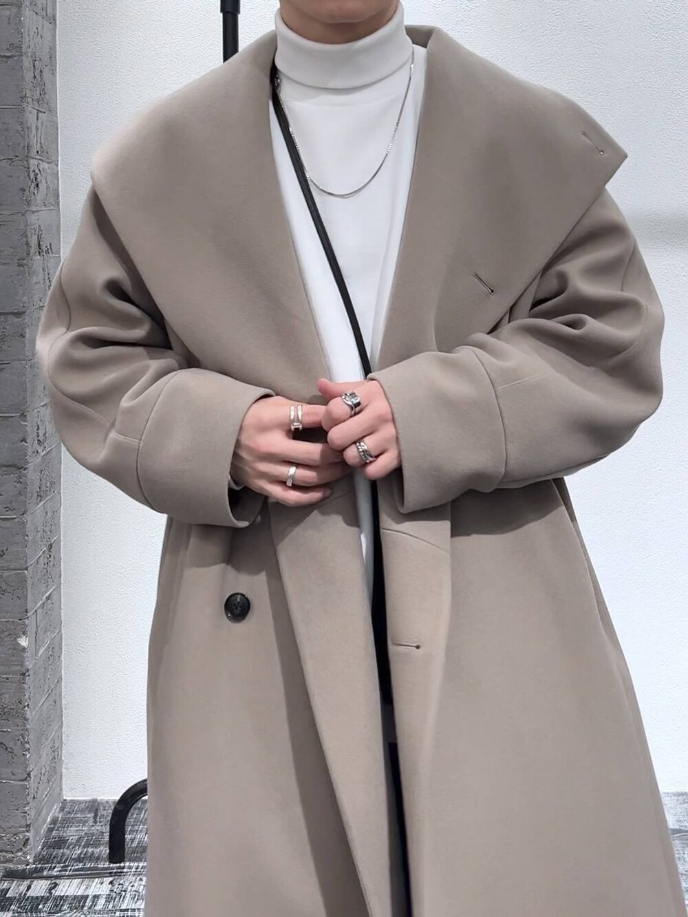 ブルー系のデニムパンツ、ブラック系のショルダーバッグ、ブラック系のドレスシューズを着用したメンズの冬コーディネートの5枚目の写真