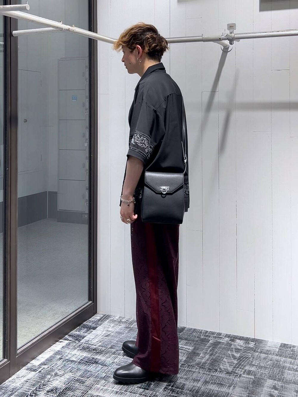 ブラック系のドレスシューズ、レッド系のその他パンツ、ブラック系のTシャツ/カットソーを着用したメンズの夏コーディネートの3枚目の写真