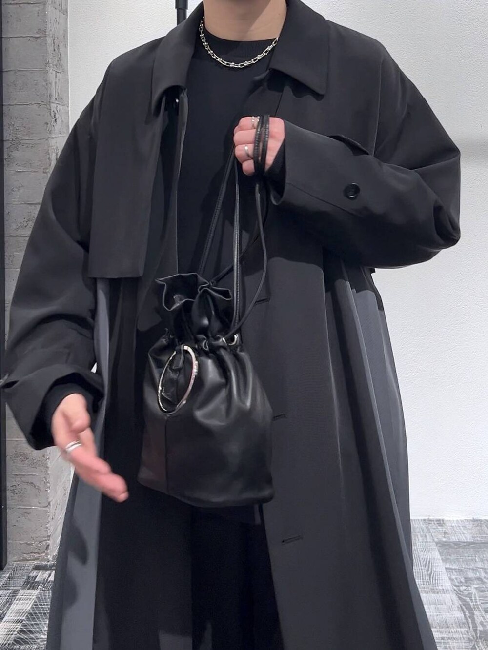 ブラック系のスウェット、ブラック系のステンカラーコート、ブラック系のドレスシューズを着用したメンズの冬コーディネートの5枚目の写真