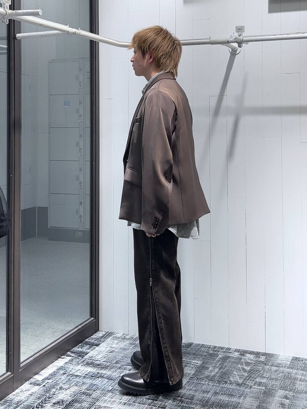 オレンジ系のデニムパンツ、ブラウン系のテーラードジャケット、ブラック系のドレスシューズを着用したメンズの春コーディネートの4枚目の写真