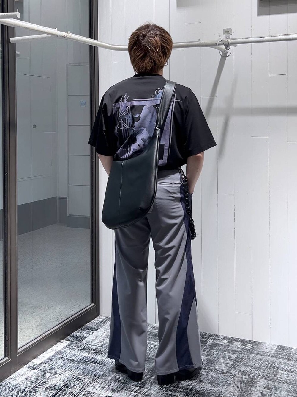 ブラック系のドレスシューズ、ブラック系のTシャツ/カットソー、ブラック系のショルダーバッグを着用したメンズの春コーディネートの4枚目の写真