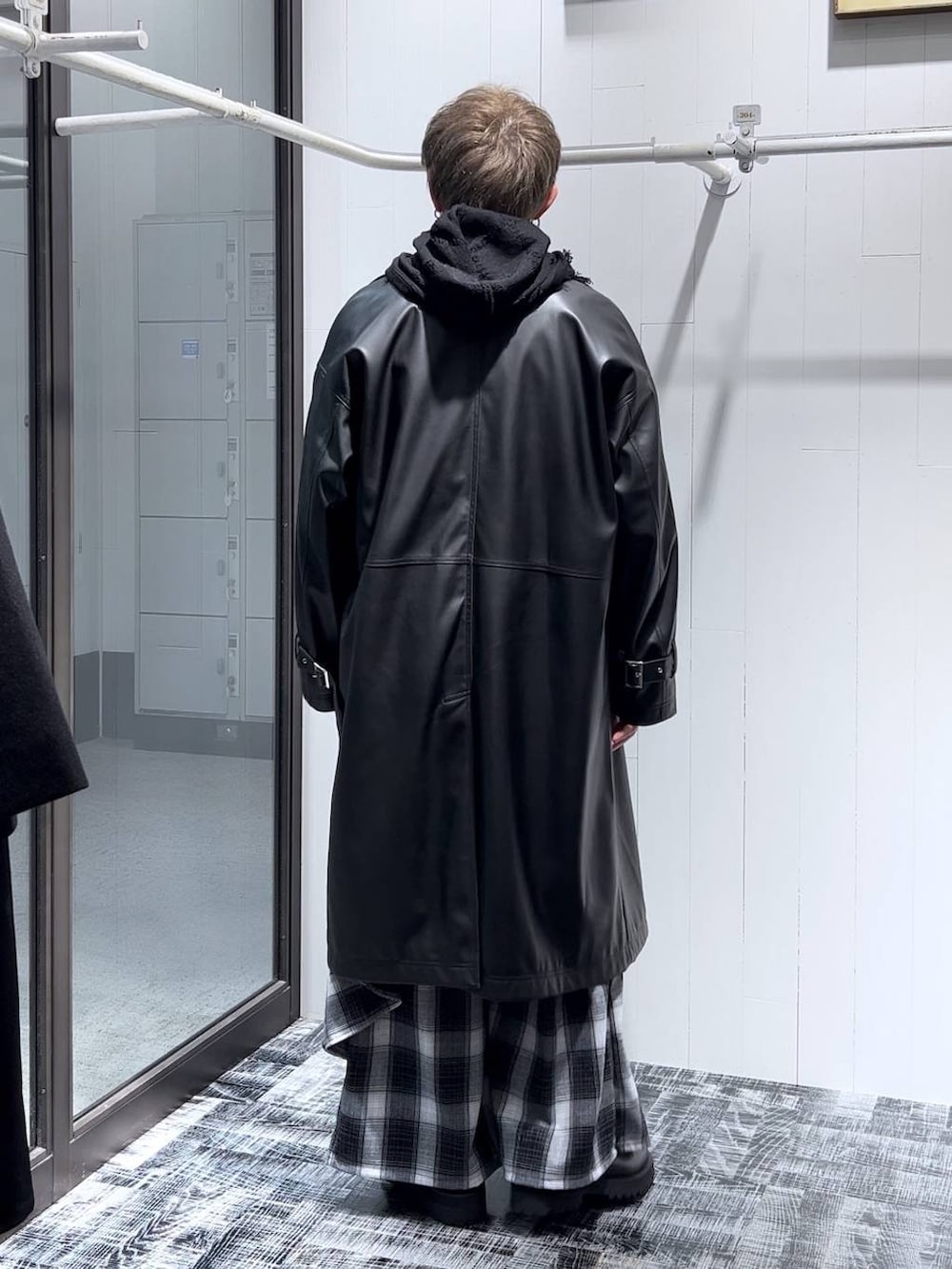 ブラック系のトレンチコート、ブラック系のその他パンツ、ブラック系のパーカーを着用したメンズの秋コーディネートの3枚目の写真