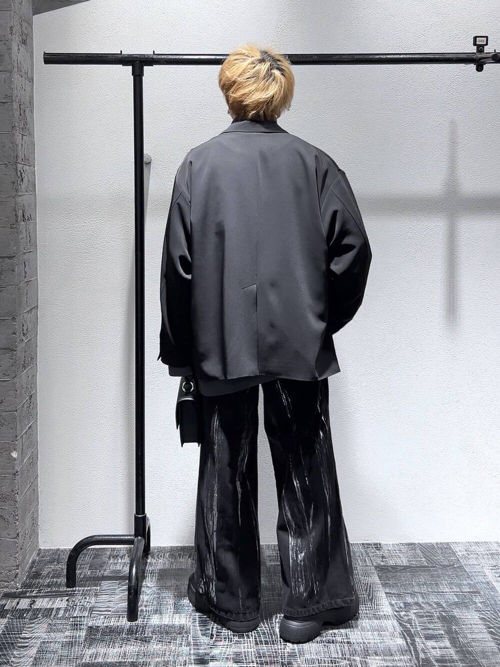 ブラック系のショルダーバッグ、グレー系のスウェット、ブラック系のブーツを着用したメンズの冬コーディネートの4枚目の写真