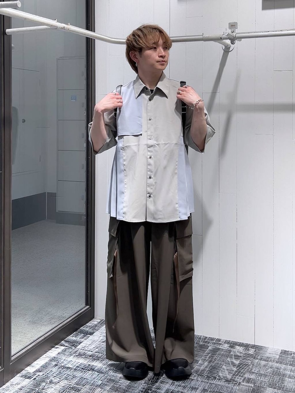 ブラウン系のカーゴパンツ、ブラック系のショルダーバッグ、グレー系のシャツ/ブラウスを着用したメンズの春コーディネートの2枚目の写真