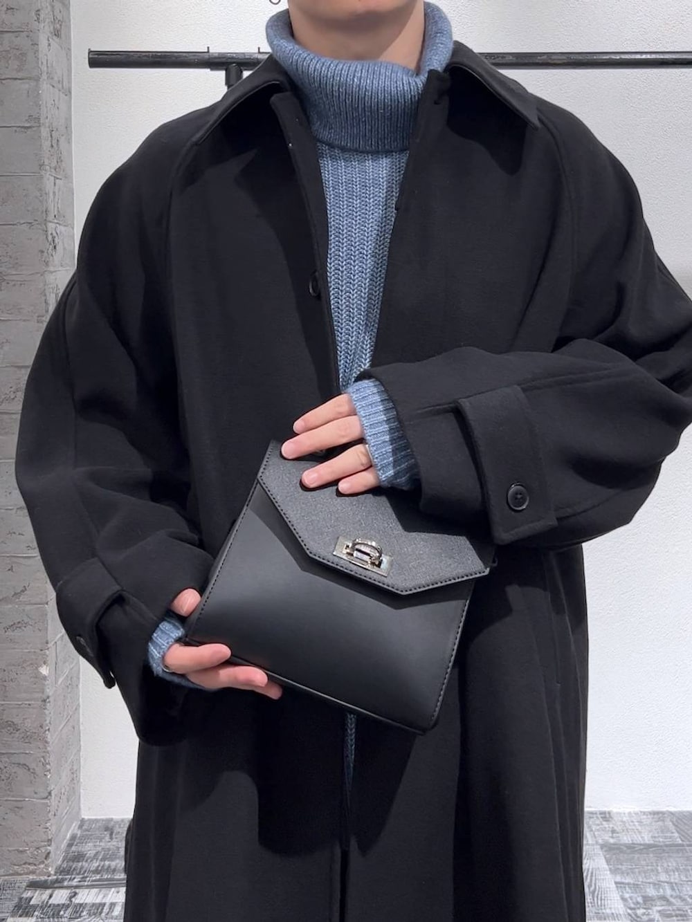 ブラック系のドレスシューズ、ブラック系のステンカラーコート、ブラック系のショルダーバッグを着用したメンズの秋コーディネートの4枚目の写真