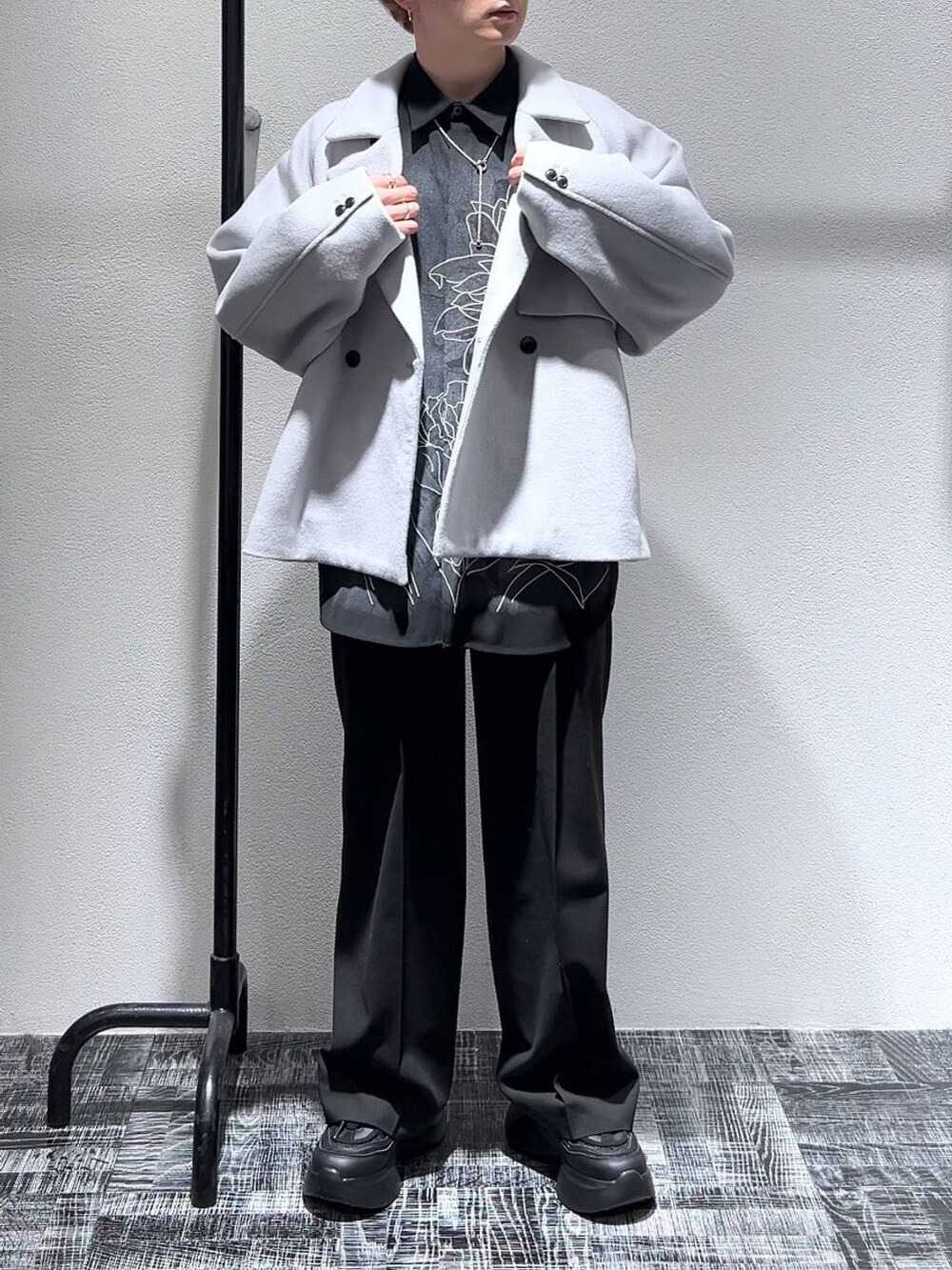 グレー系のブルゾン、ブラック系のスニーカー、ブラック系のスラックスを着用したメンズの冬コーディネートの2枚目の写真