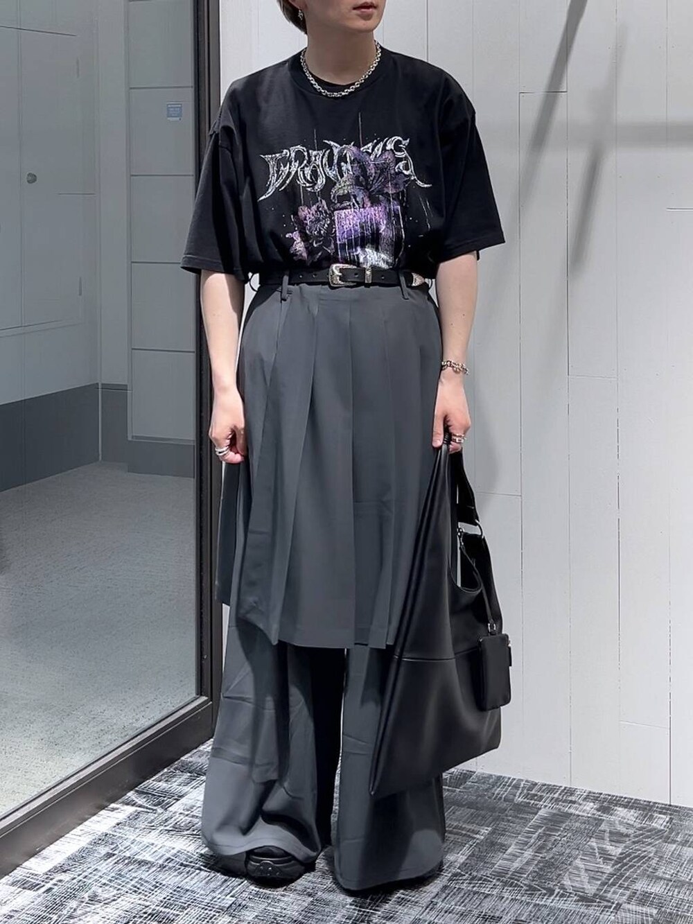ブラック系のサンダル、ブラック系のTシャツ/カットソー、ブラック系のトートバッグを着用したメンズの春コーディネートの2枚目の写真