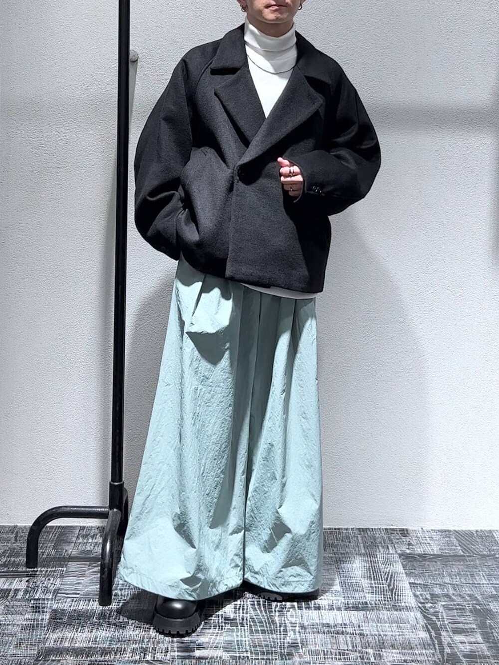 ブラック系のブルゾン、ブラック系のブーツ、ホワイト系のスウェットを着用したメンズの秋コーディネートの2枚目の写真