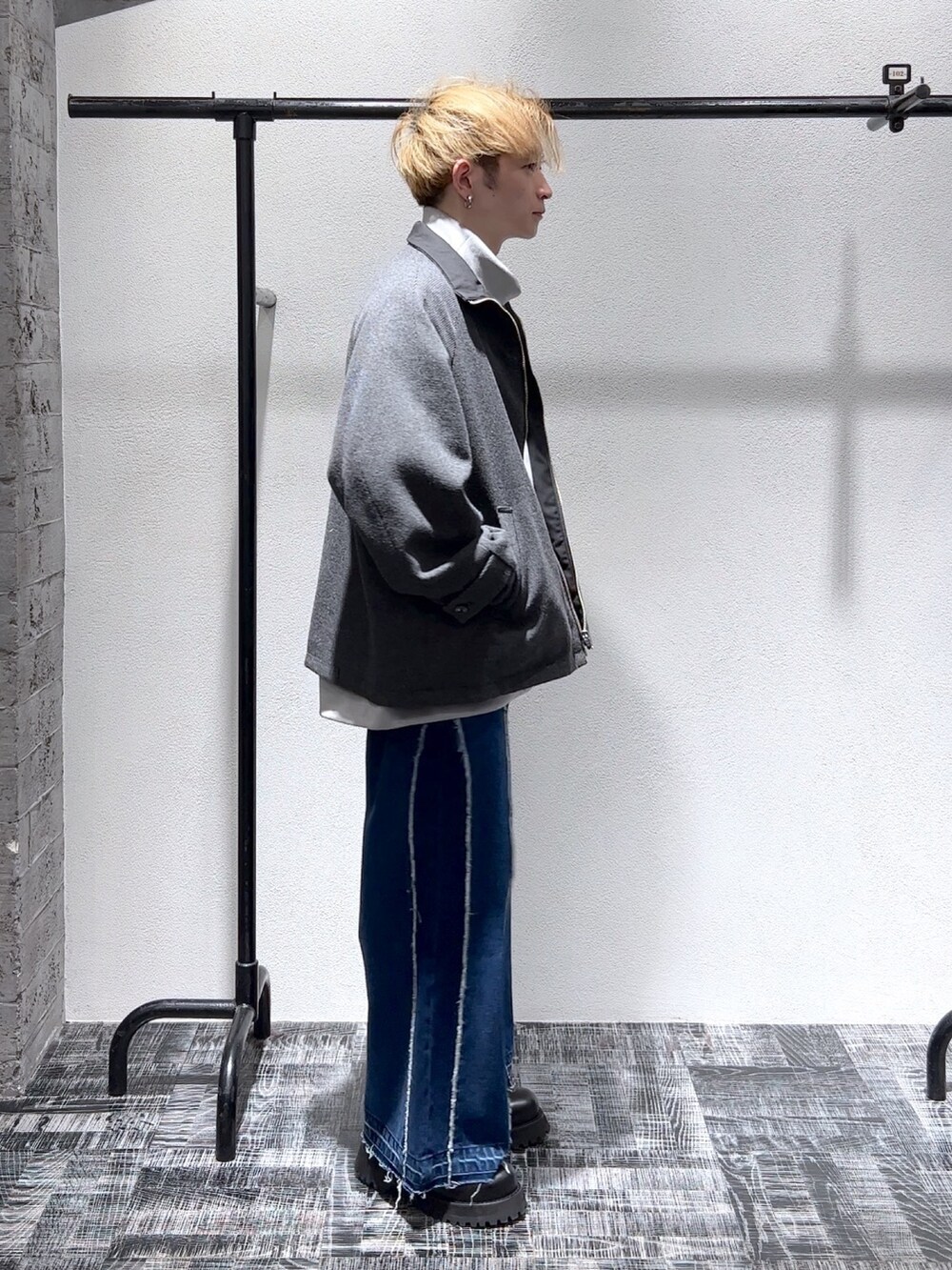 グレー系のスウェット、ブルー系のデニムパンツ、ブラック系のジャケット/アウターを着用したメンズの秋コーディネートの3枚目の写真