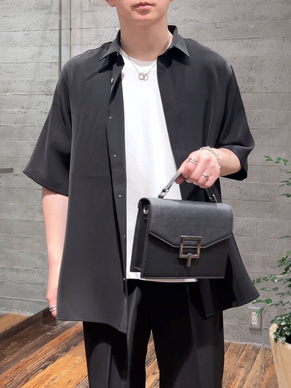 ブラック系のスラックス、ブラック系のシャツ/ブラウス、ブラック系のサンダルを着用したメンズの夏コーディネートの5枚目の写真