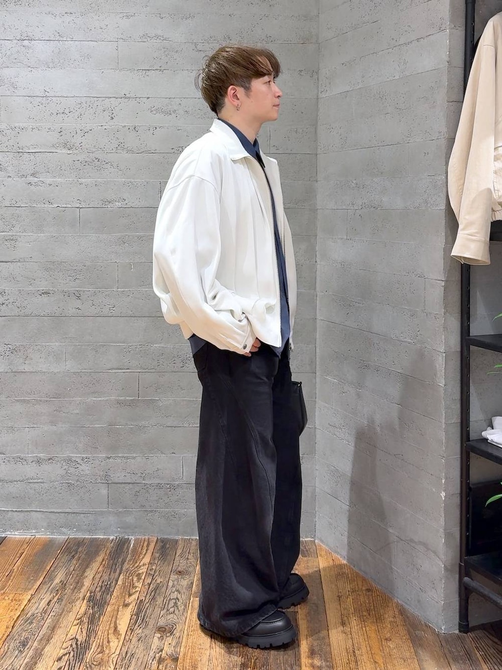 ブラック系のドレスシューズ、ブラック系のデニムパンツ、ホワイト系のブルゾンを着用したメンズの春コーディネートの2枚目の写真