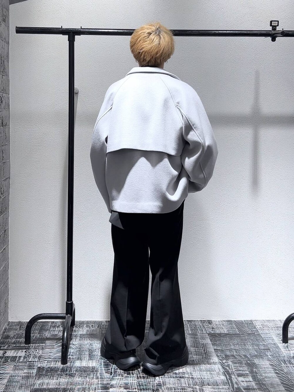 グレー系のブルゾン、ブラック系のスニーカー、ブラック系のスラックスを着用したメンズの冬コーディネートの3枚目の写真