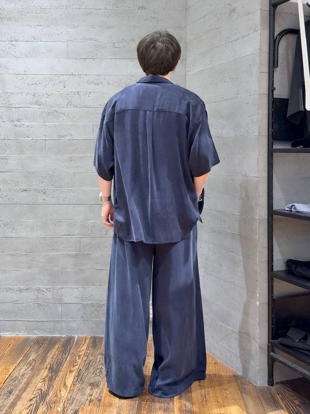 ブルー系のスラックス、ブラック系のサンダル、ホワイト系のTシャツ/カットソーを着用したメンズの夏コーディネートの3枚目の写真