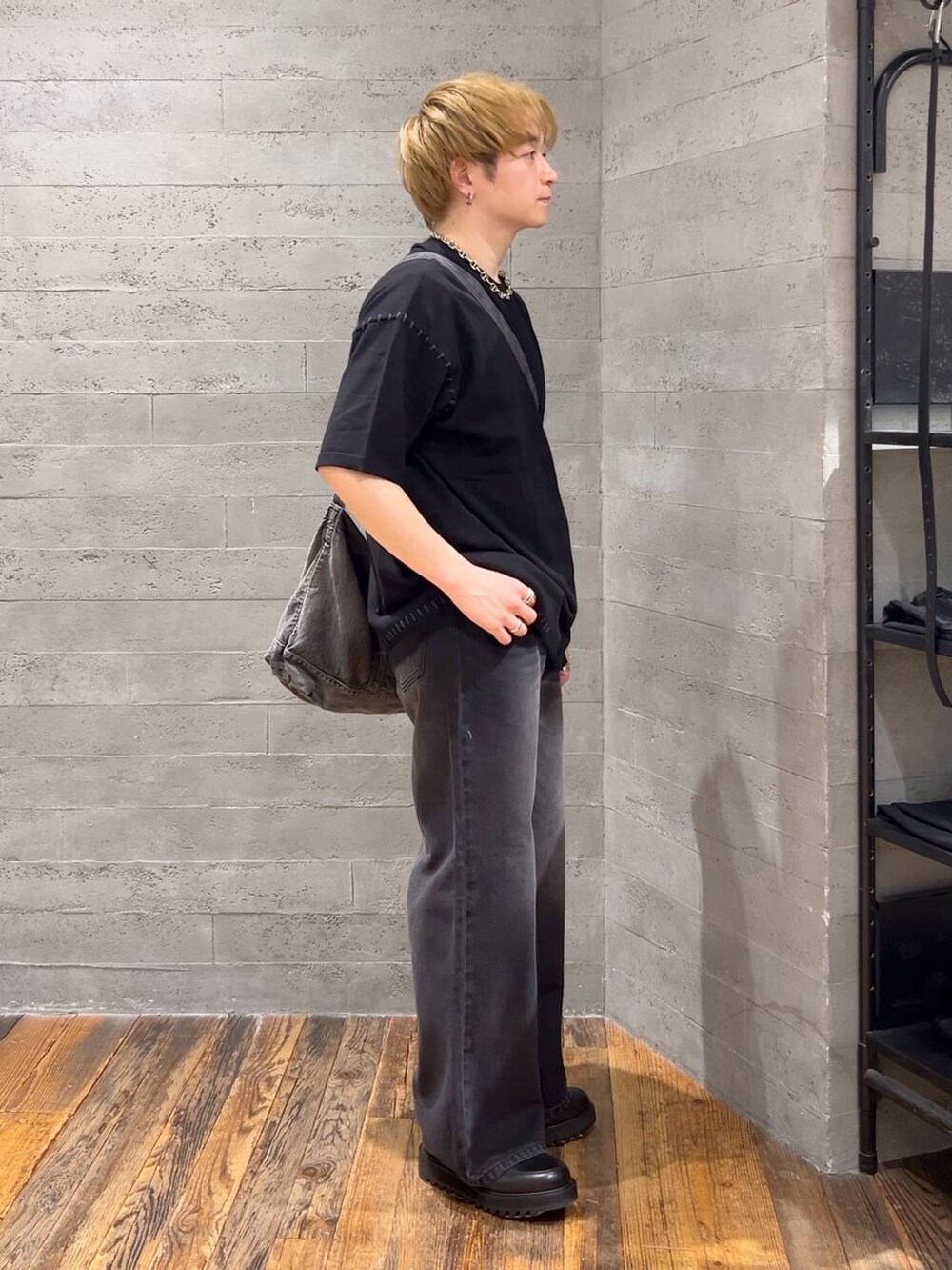 ブラック系のショルダーバッグ、ブラック系のドレスシューズ、ブラック系のデニムパンツを着用したメンズの春コーディネートの2枚目の写真