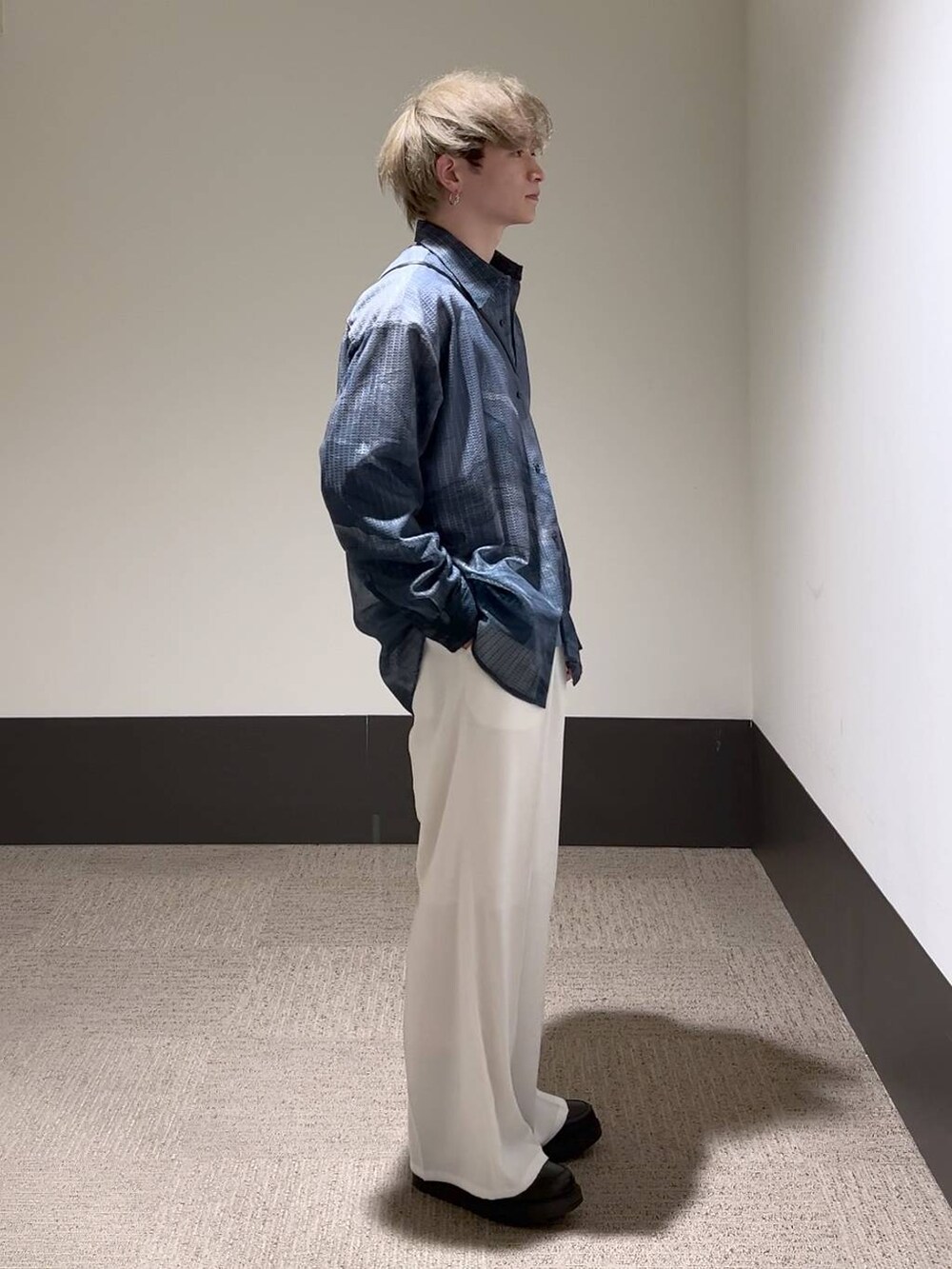 ホワイト系のスラックス、ブルー系のTシャツ/カットソー、ブラック系のショルダーバッグを着用したメンズの冬コーディネートの3枚目の写真