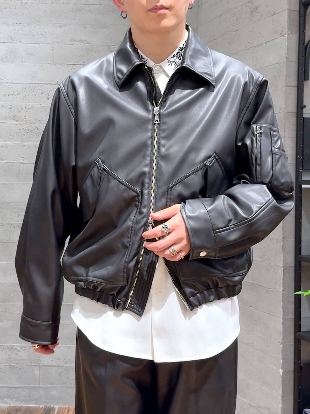 ブラック系のブルゾン、ブラック系のスラックス、ブラック系のローファーを着用したメンズの夏コーディネートの5枚目の写真