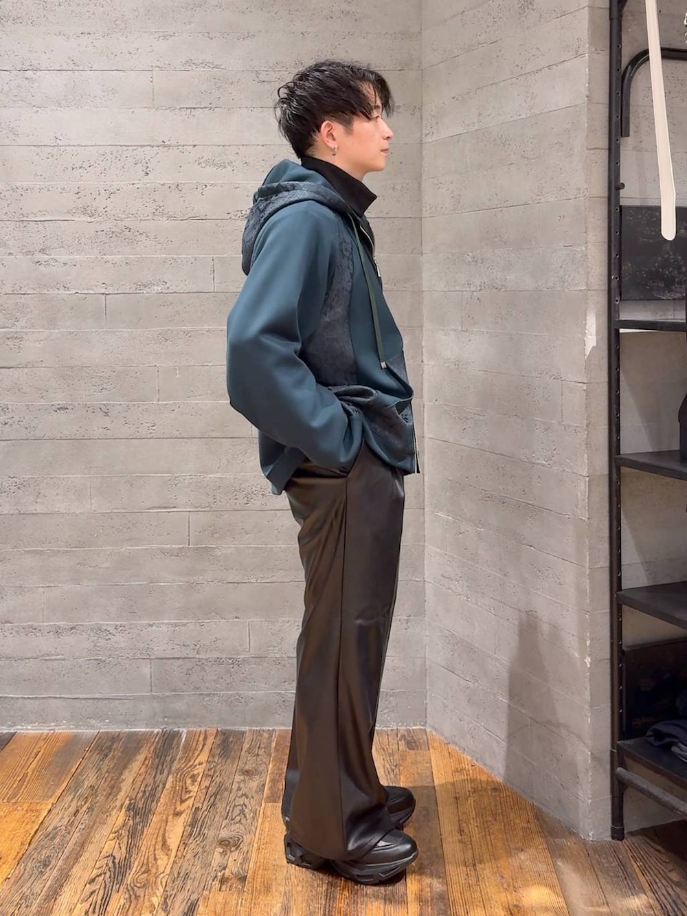 ブラック系のスラックス、ブラック系のスニーカー、ブラック系のショルダーバッグを着用したメンズの秋コーディネートの2枚目の写真