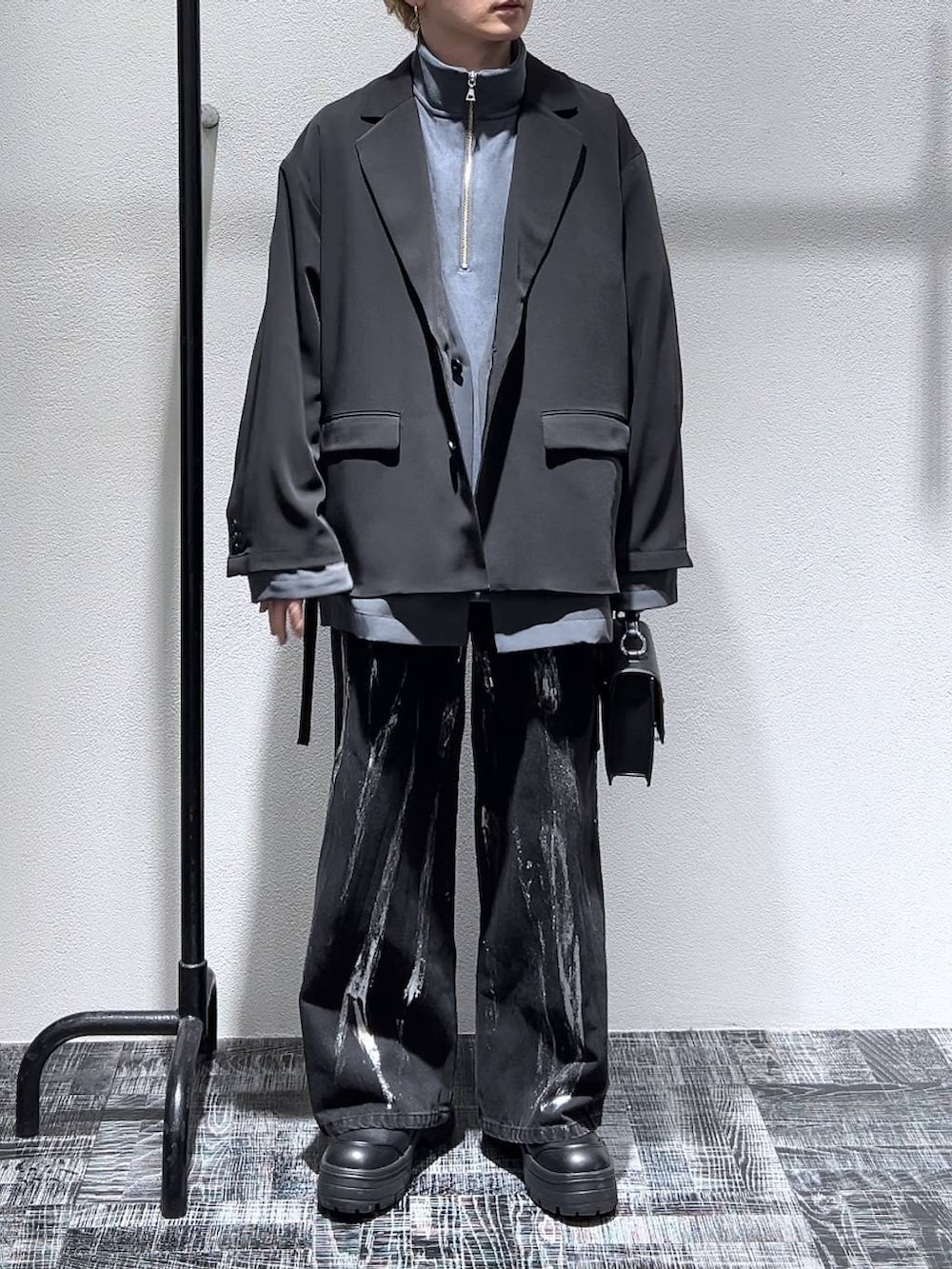 ブラック系のショルダーバッグ、グレー系のスウェット、ブラック系のブーツを着用したメンズの冬コーディネートの2枚目の写真