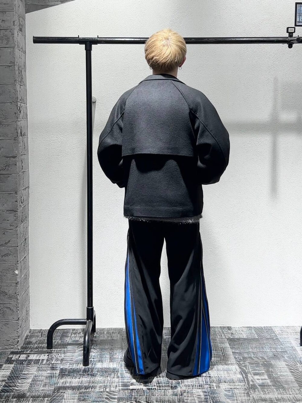 ブラック系のブルゾン、ブラック系のブーツ、ブルー系のスラックスを着用したメンズの秋コーディネートの4枚目の写真