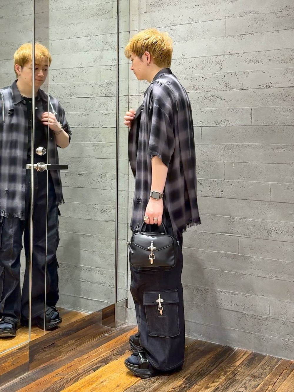 ブラック系のサンダル、ブルー系のデニムパンツ、ブラック系のショルダーバッグを着用したメンズの春コーディネートの4枚目の写真