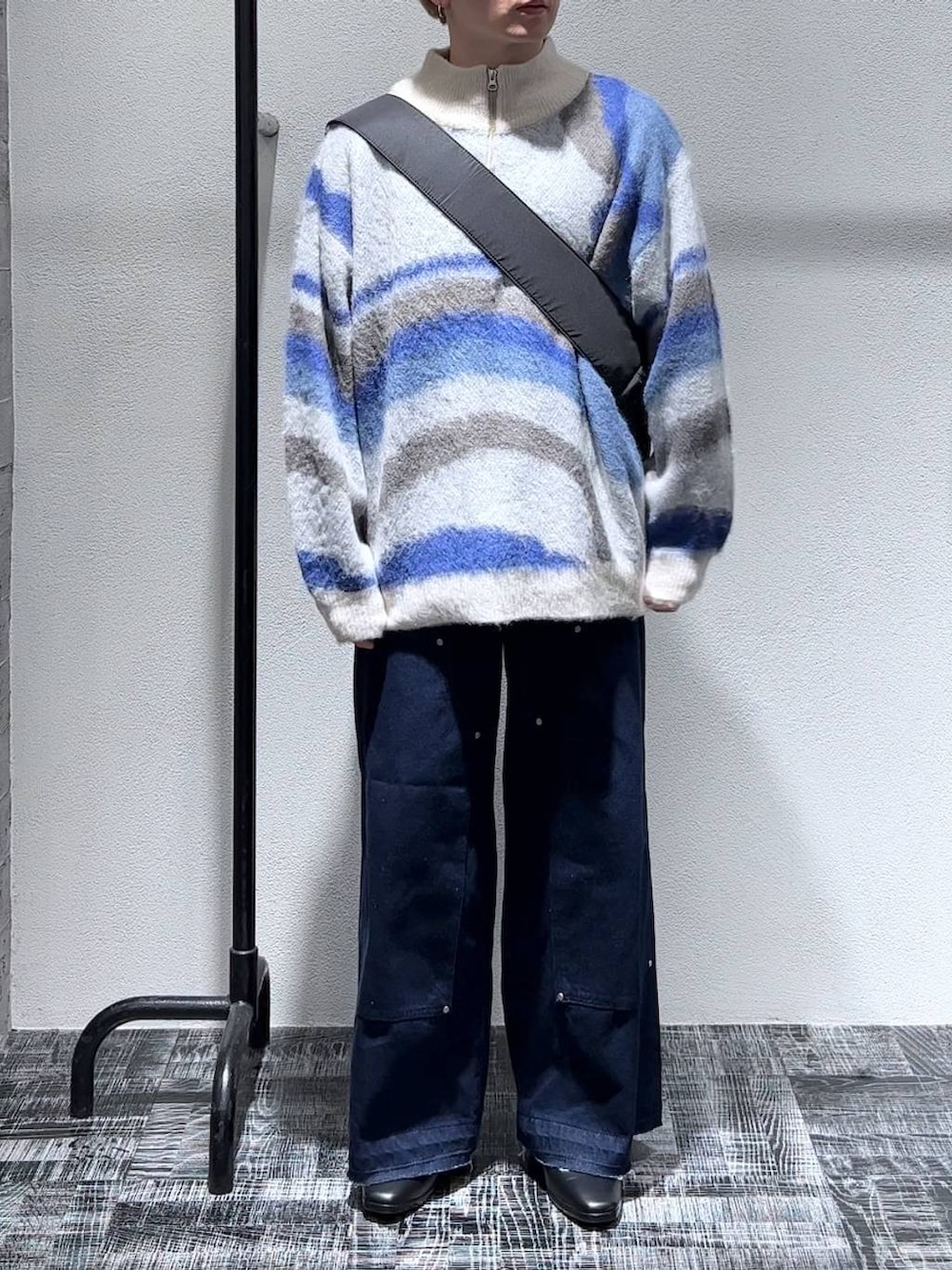 ブラック系のドレスシューズ、ブルー系のデニムパンツ、ホワイト系のニット/セーターを着用したメンズの秋コーディネートの2枚目の写真