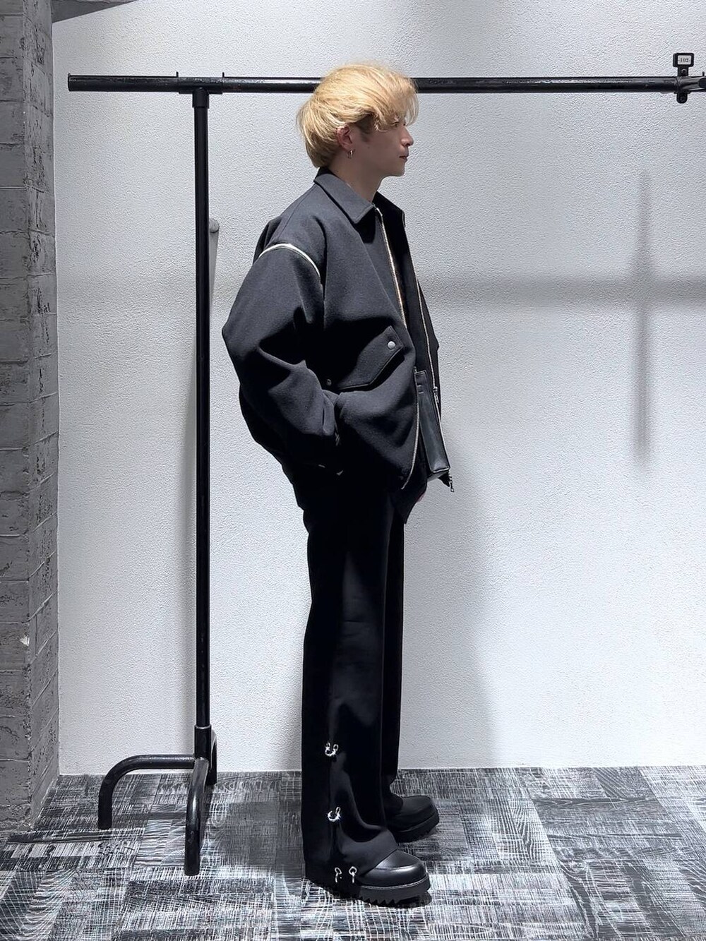 ブラック系のショルダーバッグ、ブラック系のニット/セーター、ブラック系のブルゾンを着用したメンズの冬コーディネートの3枚目の写真