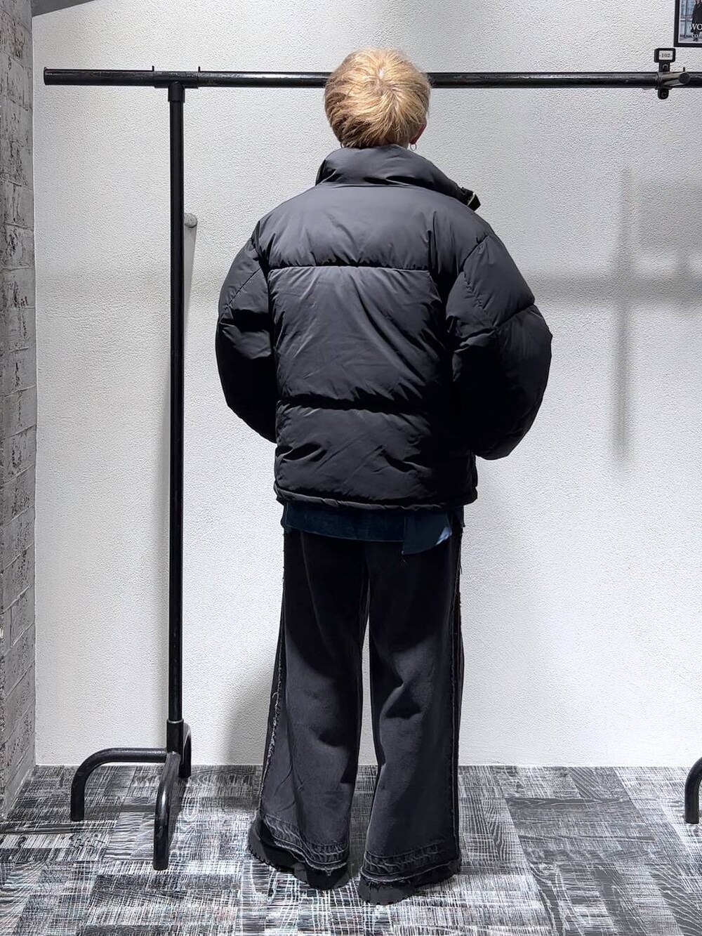 ブラック系のデニムパンツ、ブラック系のダウンジャケット/コート、ブラック系のブーツを着用したメンズの秋コーディネートの4枚目の写真