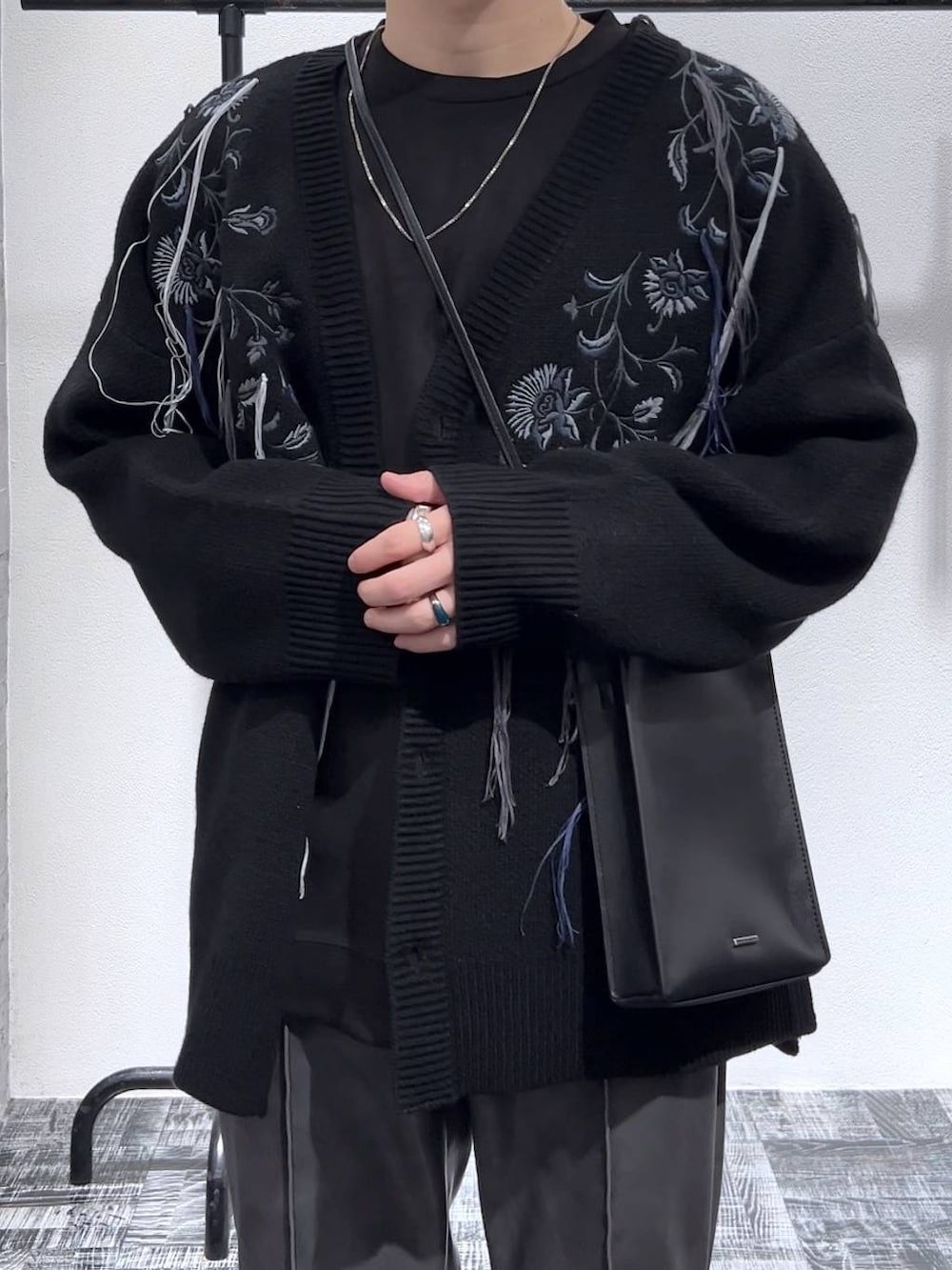 ブラック系のカーディガン/ボレロ、ブラック系のブーツ、ブラック系のショルダーバッグを着用したメンズの冬コーディネートの5枚目の写真