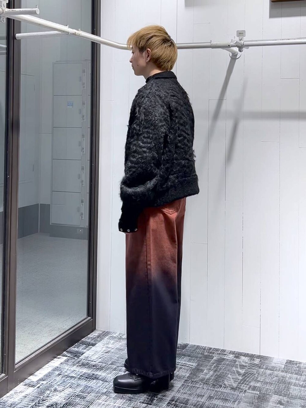 オレンジ系のデニムパンツ、ブラック系のTシャツ/カットソー、ブラック系のブーツを着用したメンズの冬コーディネートの4枚目の写真