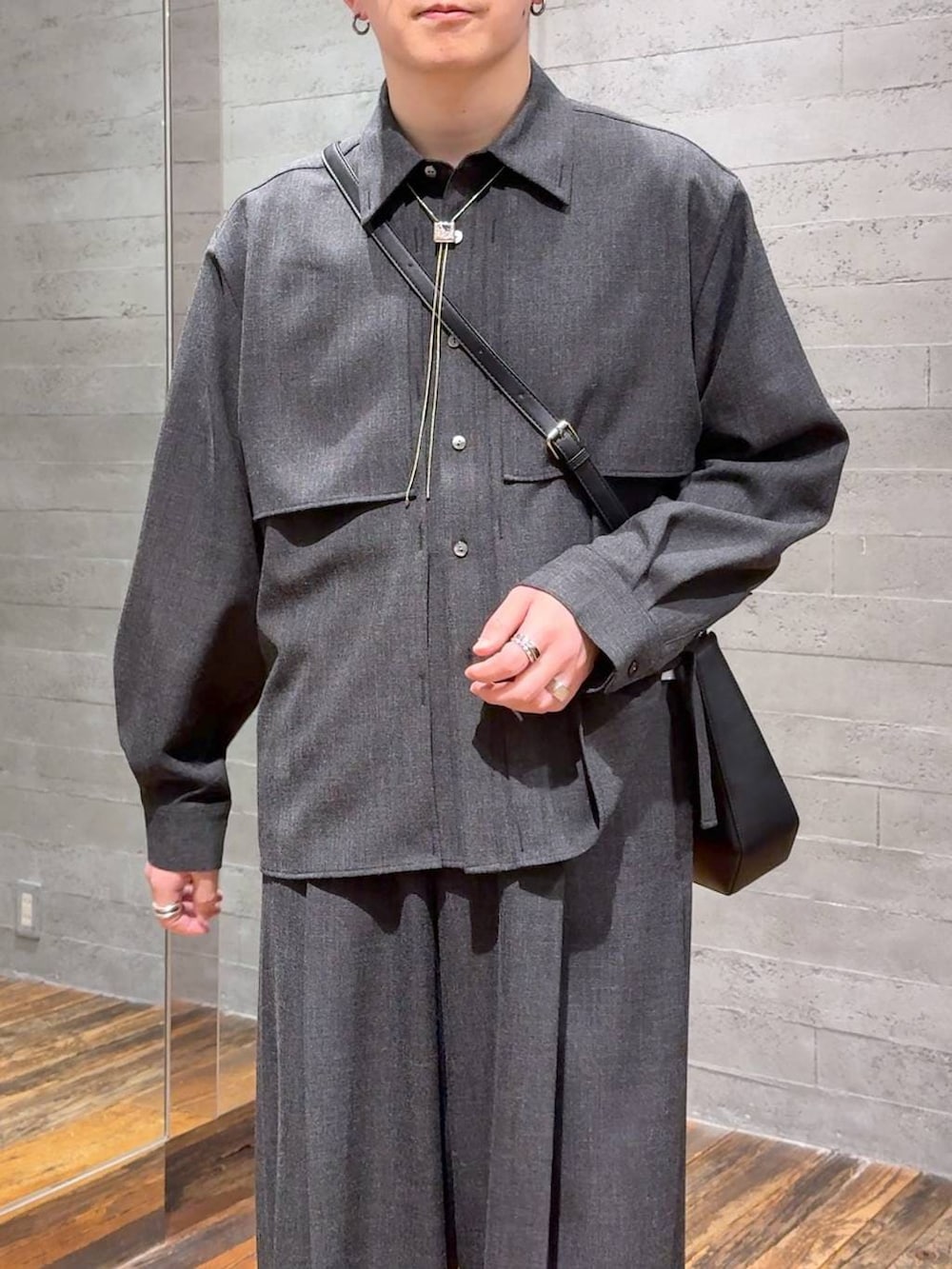 ブラック系のドレスシューズ、ブラック系のスラックス、ブラック系のショルダーバッグを着用したメンズの春コーディネートの5枚目の写真